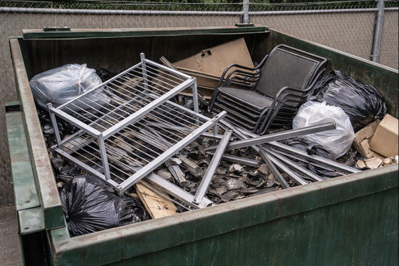 Metal furniture thrown into a dumpster causing excess weight and disposal costs